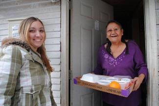 Woman receiving her Meals on Wheels delivery