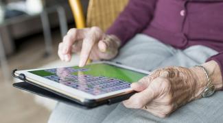 Older person holding a tablet device