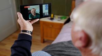 Older man video chatting on a phone