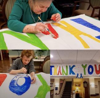 Women painting a thank-you sign